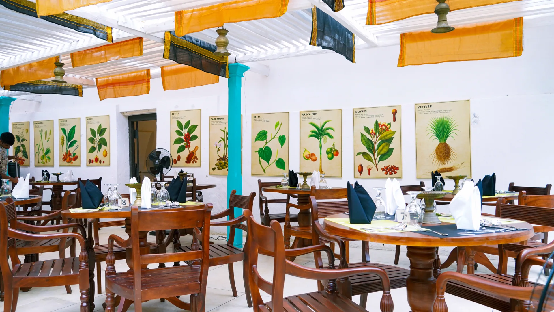 Restaurant dining hall with botanical spice illustrations and hanging fabric panels
